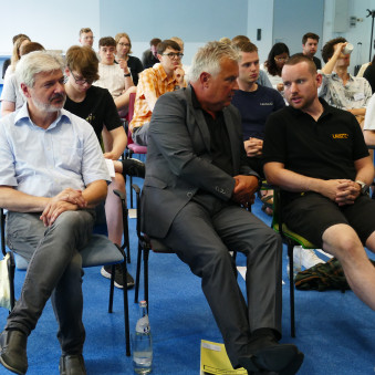 © QLEE/Maria Göckeritz Personen sitzen auf Stühlen