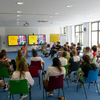 Gruppe von Personen sitzen in einem Stuhlkreis