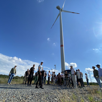 Gruppe von Personen vor einer Windenergieanlage