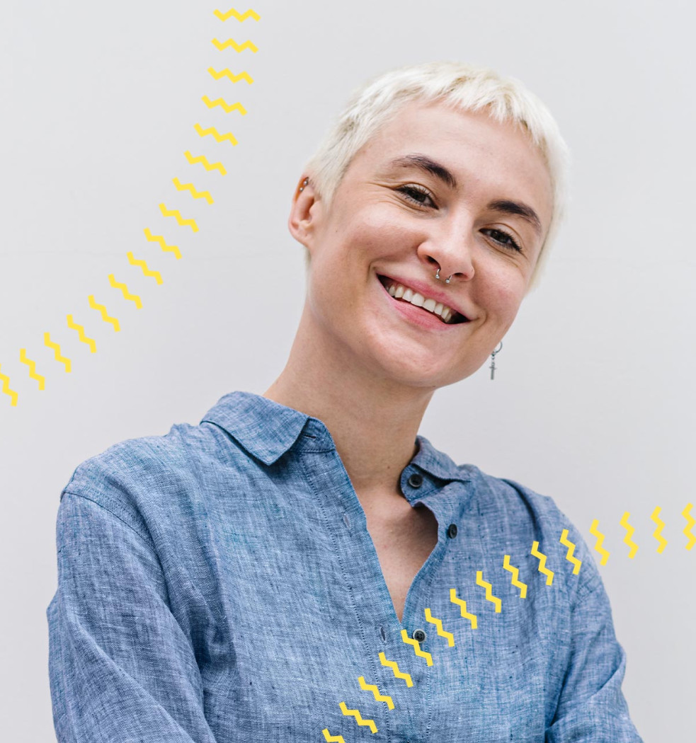 zukunftsakademie-slideshow-svenja Porträt einer lächelnden Frau in blauem Hemd vor hellem Hintergrund mit gelben Wellenlinien.