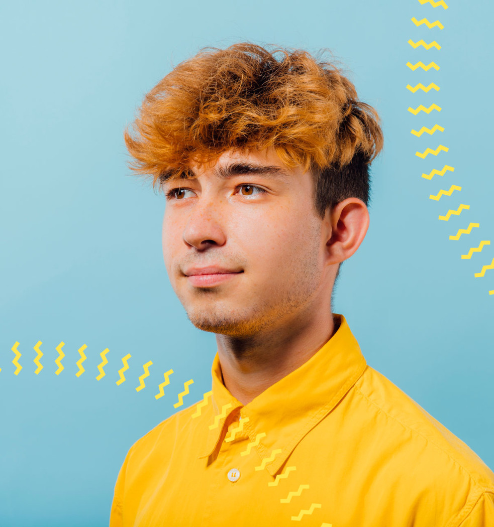 zukunftsakademie-slideshow-julien Porträt eines jungen Mannes in gelbem Hemd vor blauem Hintergrund mit gelben Wellenlinien